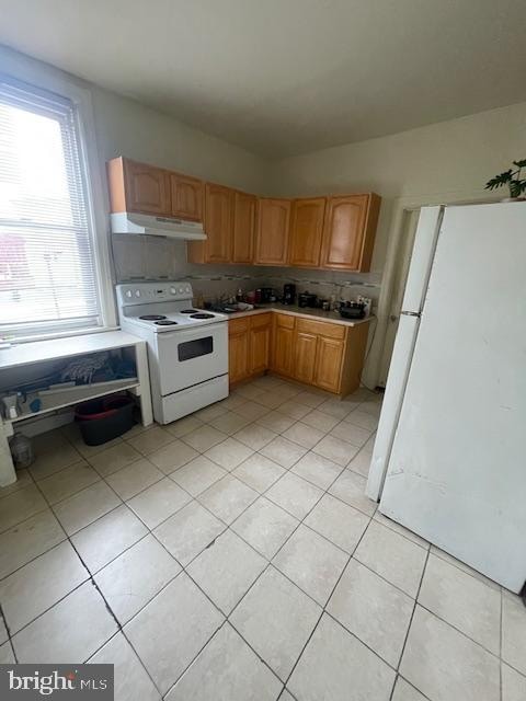 kitchen with light tile floors, tasteful backsplash, and white appliances