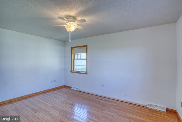 spare room with ceiling fan, light hardwood / wood-style flooring, and a textured ceiling