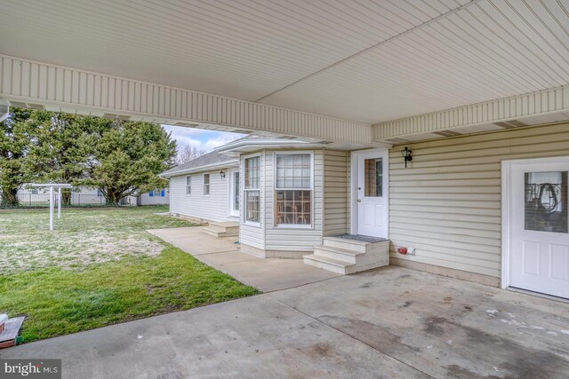 property entrance with a patio area and a lawn