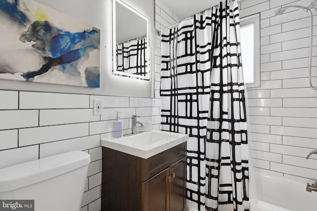 full bathroom with vanity, shower / bath combination with curtain, toilet, and tile walls