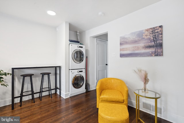 laundry area with dark wood-type flooring and stacked washing maching and dryer