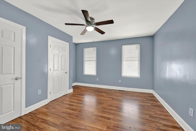 unfurnished room with ceiling fan and dark hardwood / wood-style flooring