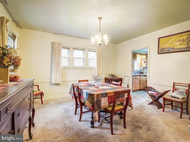 carpeted dining area with a notable chandelier