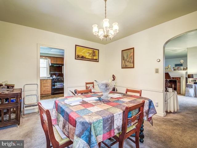 carpeted dining room with a chandelier