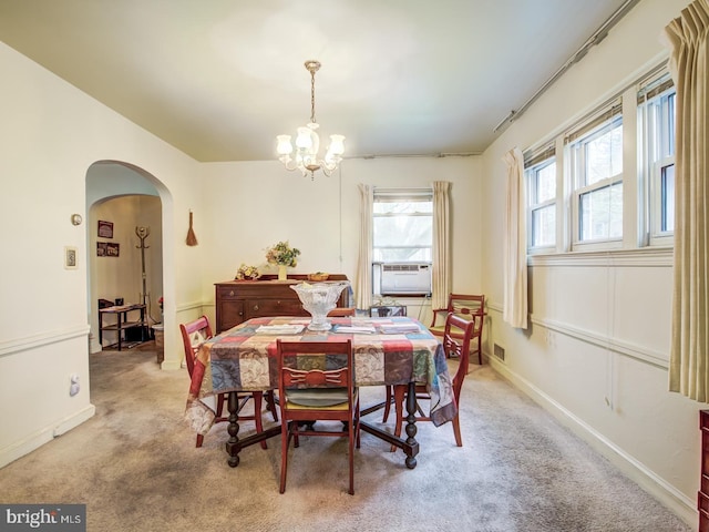 carpeted dining room featuring a chandelier