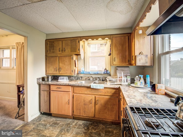 kitchen featuring dark tile flooring, a drop ceiling, sink, and stove