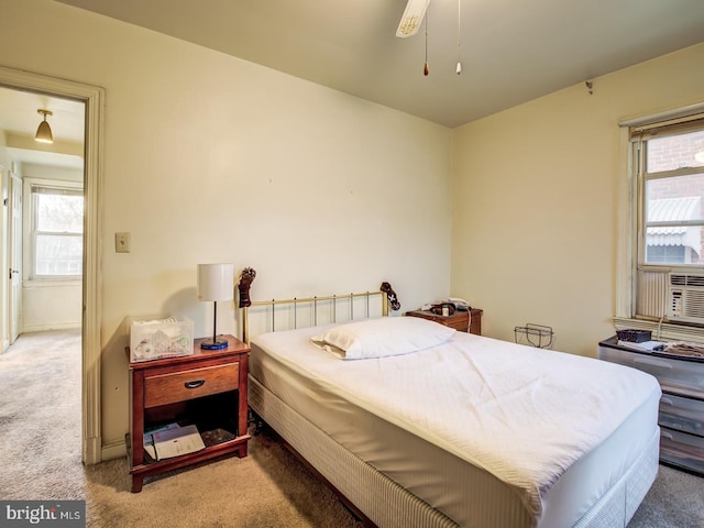 carpeted bedroom featuring ceiling fan and multiple windows