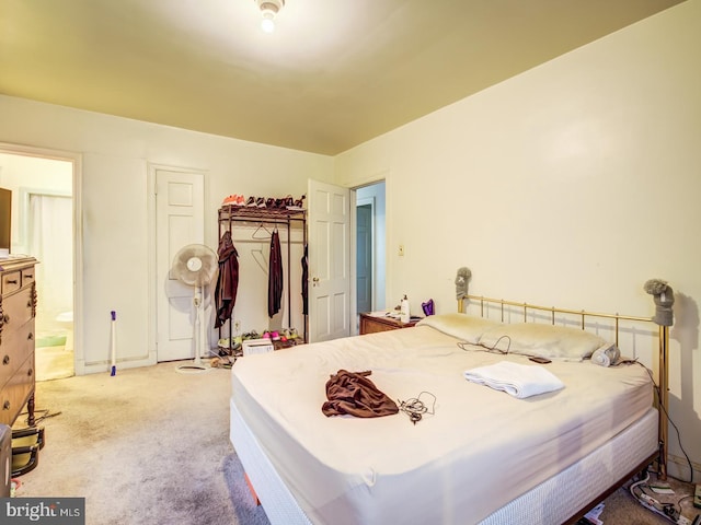 bedroom with light carpet and ensuite bathroom