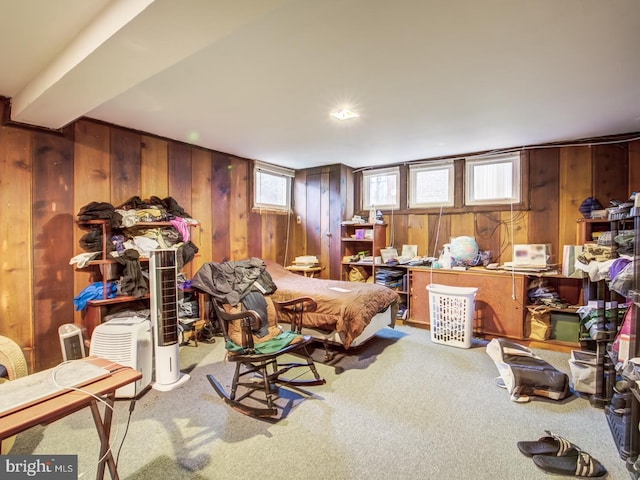 living area with carpet floors, wooden walls, and plenty of natural light