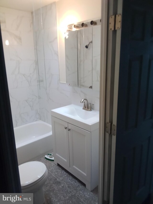 full bathroom with tasteful backsplash, toilet, tiled shower / bath, vanity, and tile walls