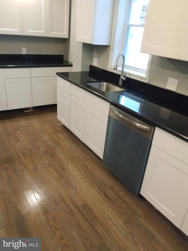 kitchen with sink, white cabinetry, dark wood-type flooring, and stainless steel dishwasher