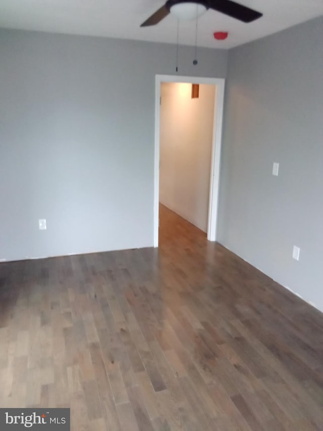 empty room with ceiling fan and dark hardwood / wood-style floors