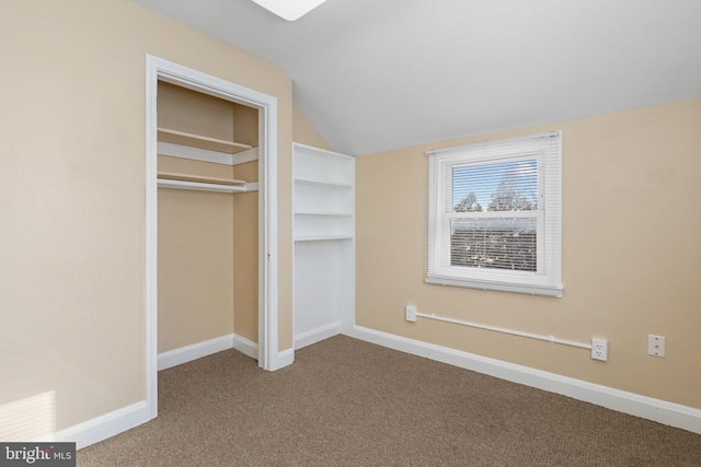 unfurnished bedroom with a closet, light colored carpet, and vaulted ceiling