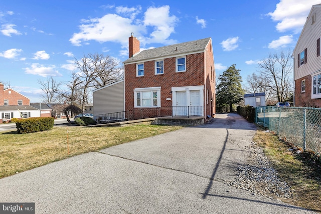 colonial house with a front yard and a garage