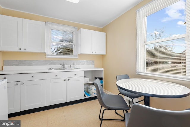 interior space featuring white cabinets, sink, and light tile floors