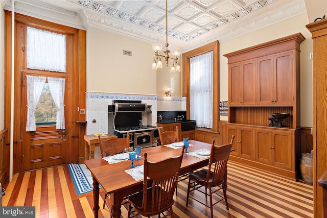 dining room featuring ornamental molding, a chandelier, and light hardwood / wood-style floors