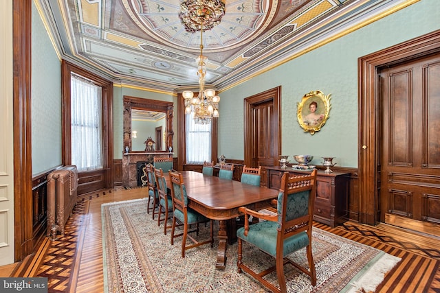 dining room with an inviting chandelier, crown molding, a raised ceiling, and a healthy amount of sunlight