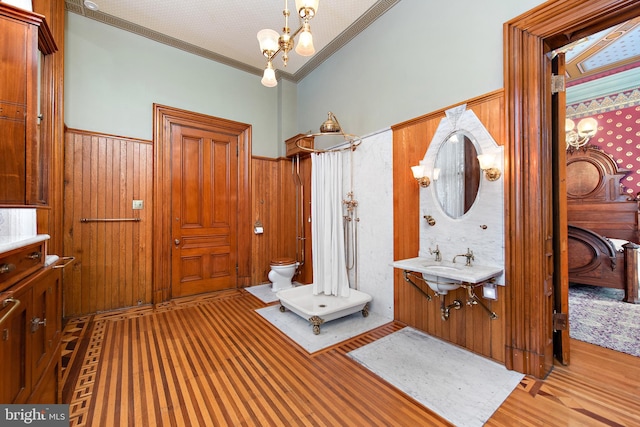 bathroom featuring toilet, ornamental molding, a notable chandelier, and vanity