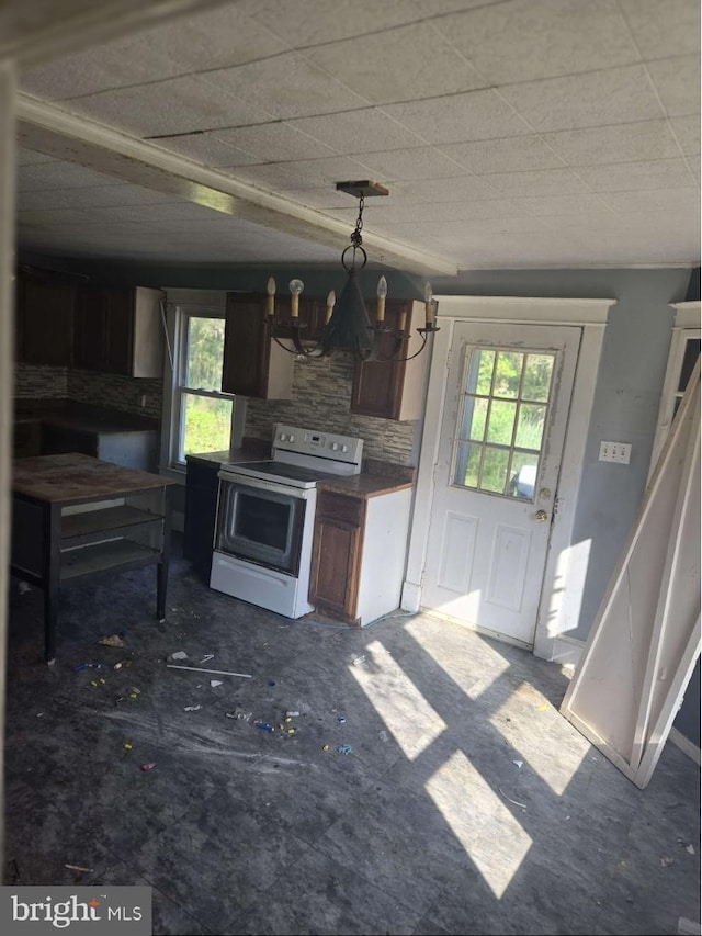 kitchen with electric range, tasteful backsplash, an inviting chandelier, and a healthy amount of sunlight