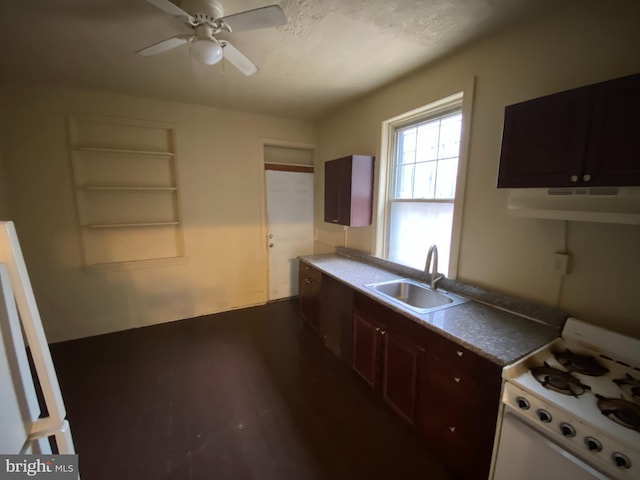 kitchen with dark brown cabinetry, ceiling fan, range, and sink