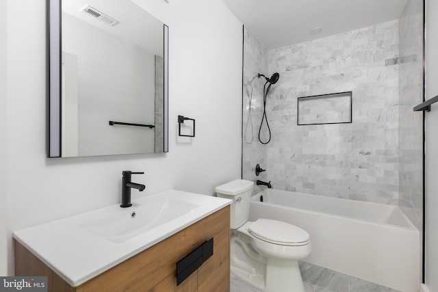 full bathroom featuring tiled shower / bath combo, vanity, tile floors, and toilet