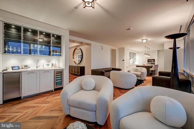 living room featuring light parquet flooring, sink, and beverage cooler