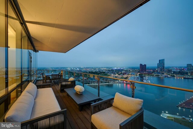 balcony at dusk with a water view and outdoor lounge area