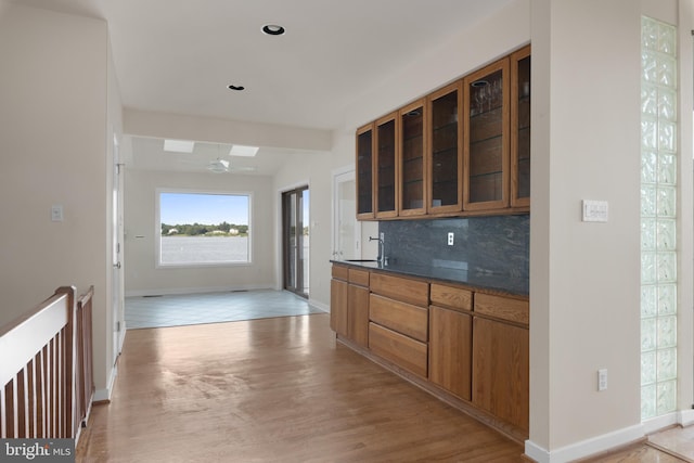 kitchen with tasteful backsplash, ceiling fan, beam ceiling, light tile floors, and sink