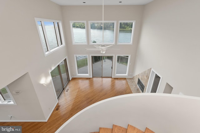 foyer entrance with plenty of natural light, light hardwood / wood-style floors, ceiling fan, and a towering ceiling