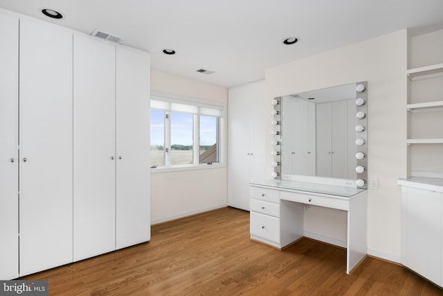 interior space with built in desk and light hardwood / wood-style flooring