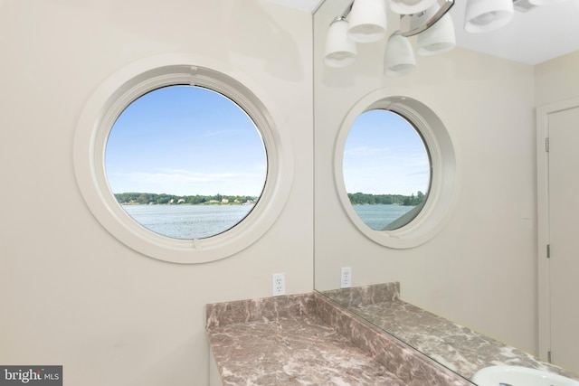 bathroom featuring an inviting chandelier and a water view