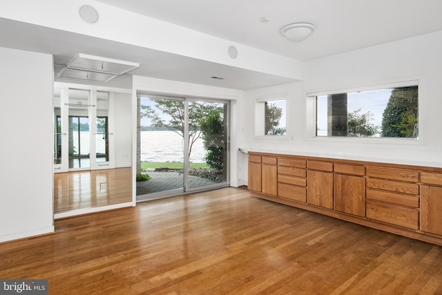 interior space with hardwood / wood-style floors and a water view