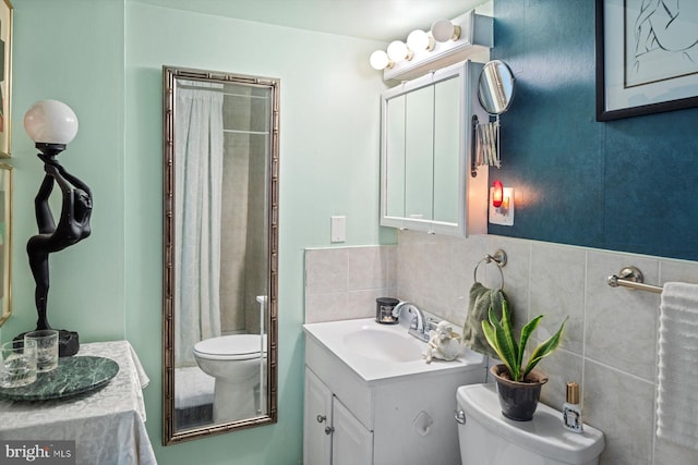 bathroom featuring tasteful backsplash, vanity with extensive cabinet space, and toilet