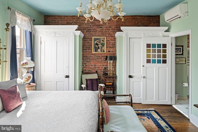 bedroom featuring brick wall, a wall mounted air conditioner, dark hardwood / wood-style flooring, and an inviting chandelier