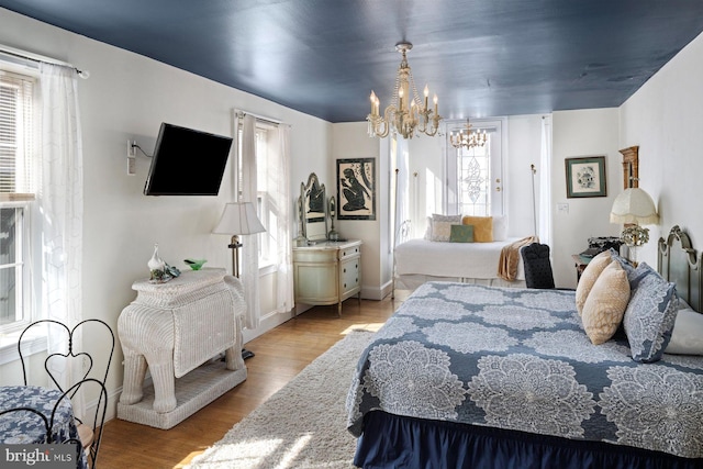 bedroom with a chandelier and light hardwood / wood-style floors