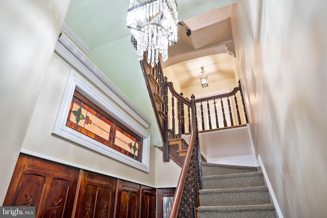 stairway with a chandelier and a high ceiling