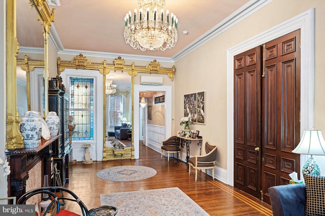 foyer entrance with a wall unit AC, dark hardwood / wood-style flooring, a notable chandelier, and ornamental molding