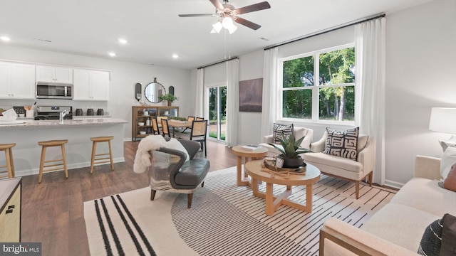 living room with dark hardwood / wood-style floors and ceiling fan