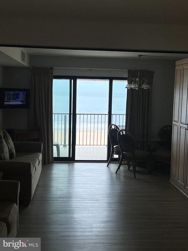 living room with a water view, a notable chandelier, and dark hardwood / wood-style floors