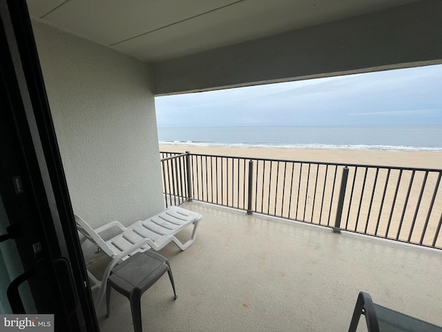 balcony with a water view and a beach view