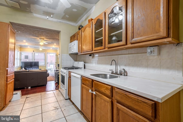 kitchen with light tile floors, ceiling fan, tasteful backsplash, white appliances, and sink