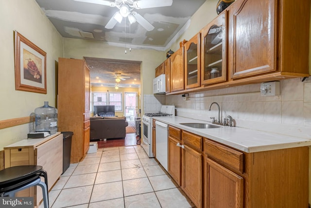 kitchen with white appliances, ceiling fan, sink, backsplash, and light tile flooring