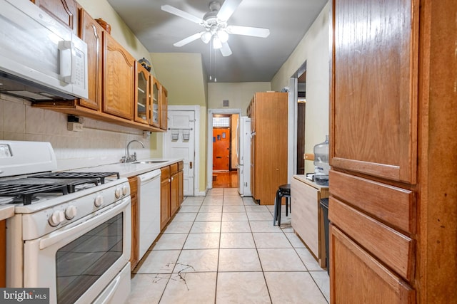 kitchen with backsplash, ceiling fan, white appliances, sink, and light tile floors