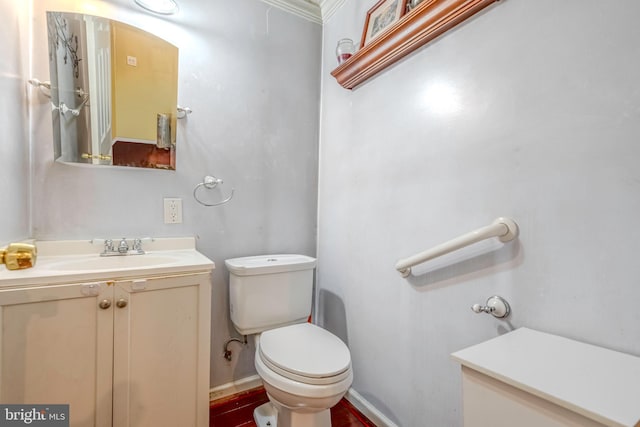 bathroom with toilet, vanity, and crown molding