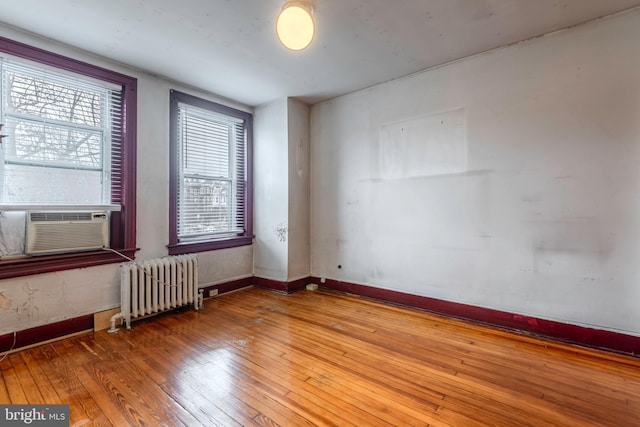 unfurnished room with hardwood / wood-style flooring and radiator