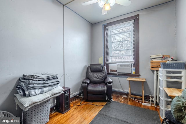 sitting room with ceiling fan and hardwood / wood-style floors