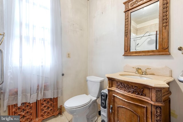 bathroom with tile flooring, toilet, and vanity