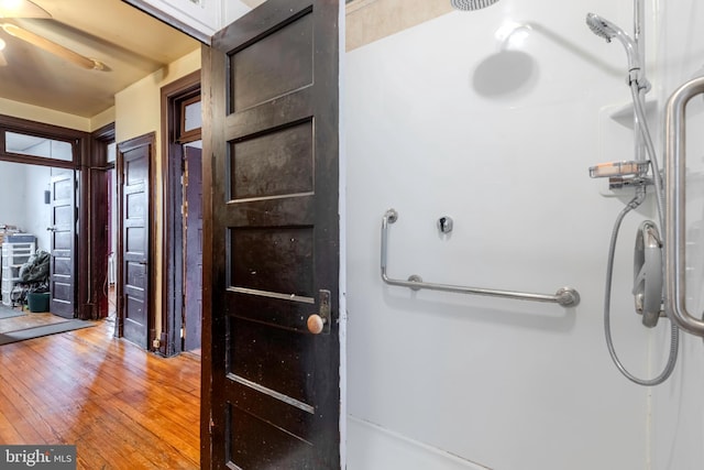 bathroom with walk in shower, ceiling fan, and hardwood / wood-style flooring