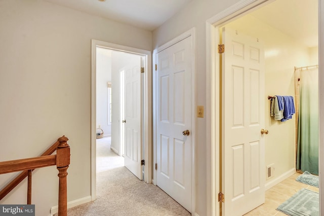 hall featuring light colored carpet