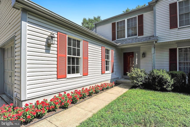 property entrance with a lawn